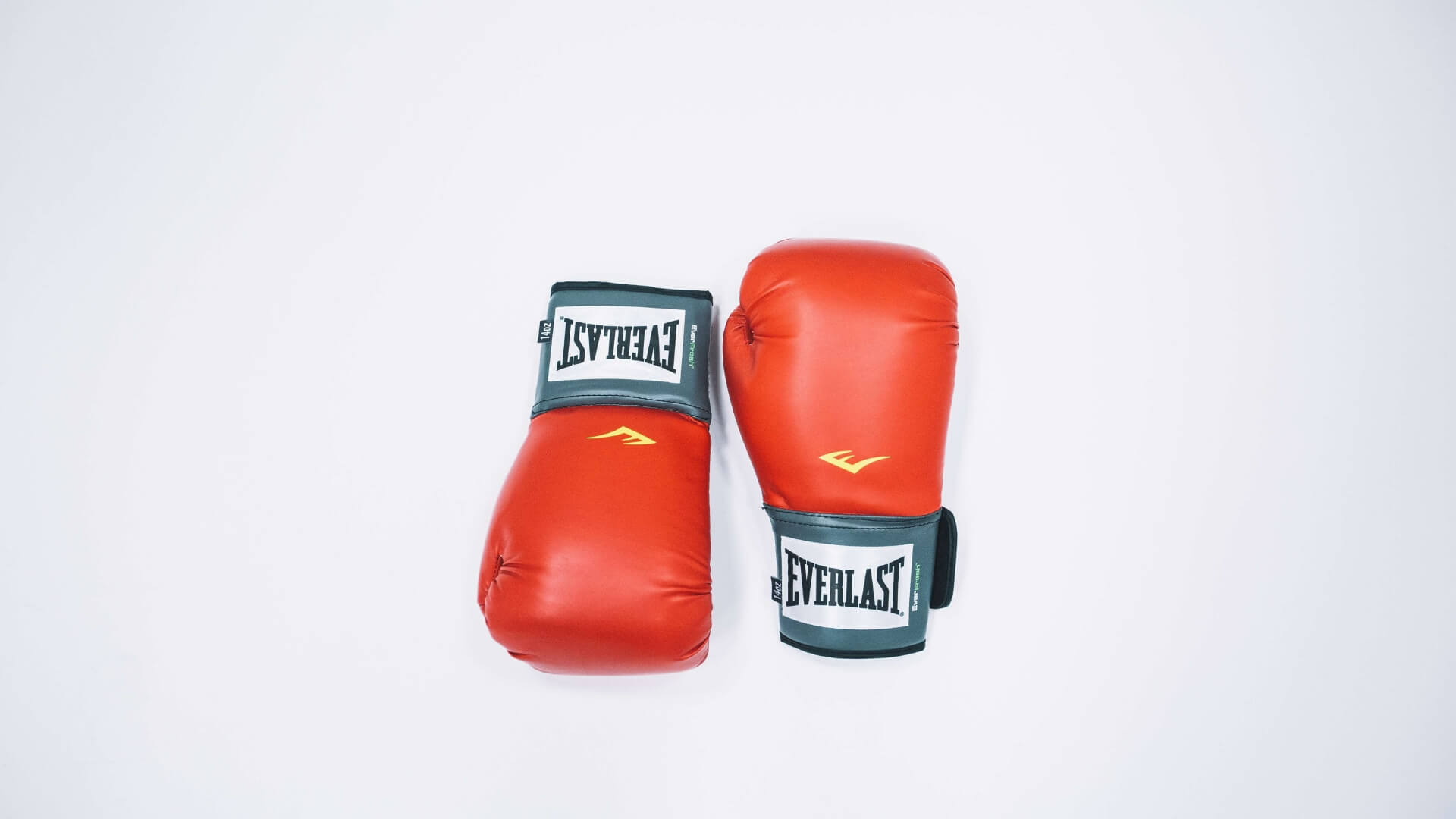 Red Everlast boxing gloves laid on a white table